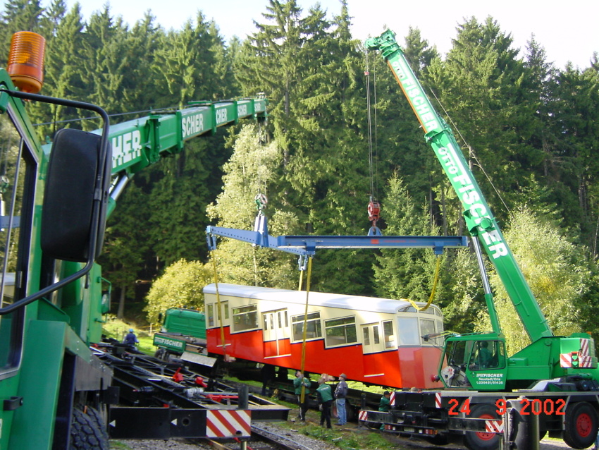 24.09.2002 Zwei Krane müssen 23,5 t Bergbahn in die Halterungen auf dem Fahrgestell fädeln.